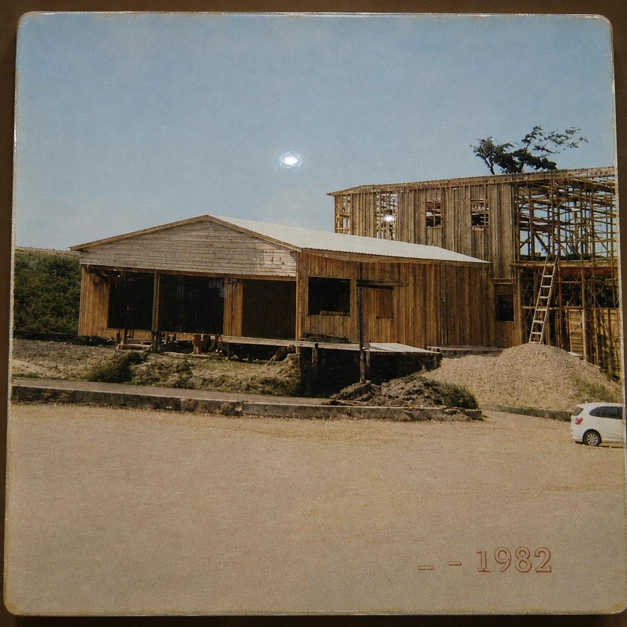 Foto histórica de 1982 mostrando a construção original do Hotel Flor da Mata em madeira, com a estrutura do segundo bloco ainda em obras