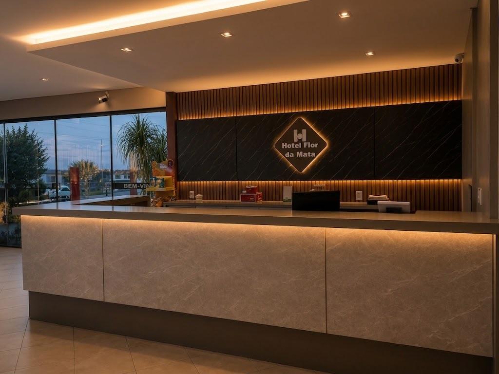 Lobby do Hotel Flor da Mata com recepção iluminada, janelas amplas e ambiente acolhedor